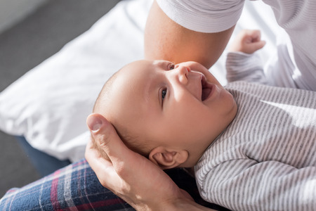 close up of parent holding smiling cute baby boyの写真素材