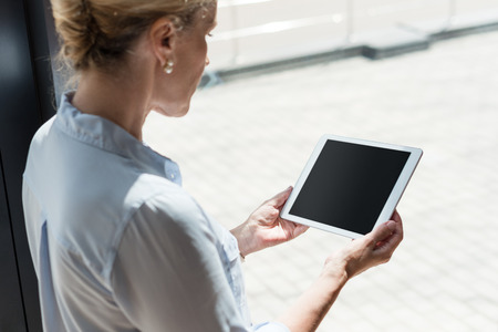 cropped shot of mature woman using digital tablet with blank screen