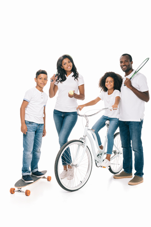 happy african american family with sport equipment smiling at camera isolated on whiteの写真素材