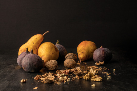 still life with organic pears, figs and walnuts on wooden tableの写真素材