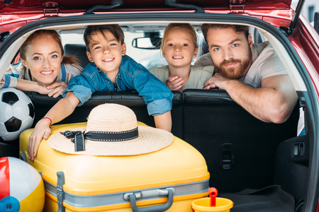 family on backseats of car ready for tripの写真素材