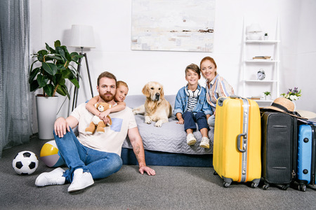 happy family with dog in bedroom ready for tripの写真素材