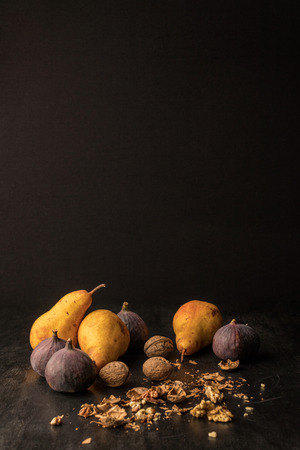 still life with organic autumnal fruits and walnuts on wooden table with copy spaceの写真素材