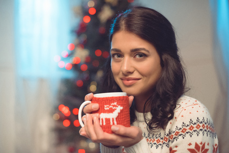 young woman with cup of hot drink on christmasの写真素材