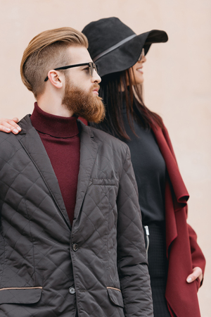 young fashionable couple looking at side outdoorsの写真素材