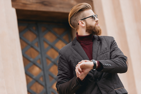 stylish bearded man waiting for date outdoorsの写真素材