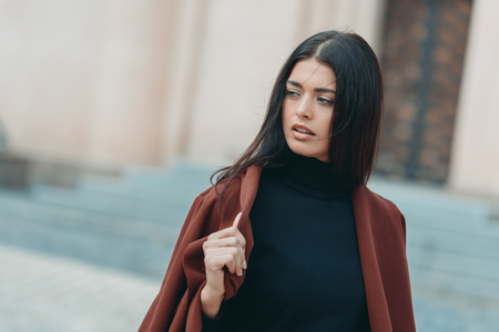 young woman in stylish coat posing outdoorsの写真素材