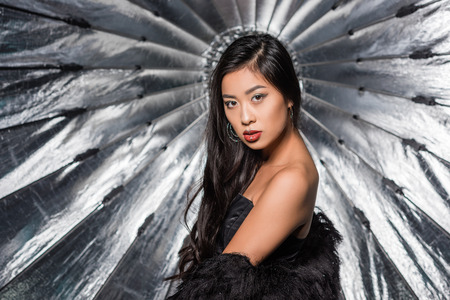 beautiful asian woman wearing ostrich feathers coat and looking at cameraの写真素材