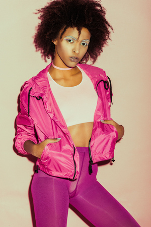 african american 80s girl in pink clothes posing for fashion shootの写真素材