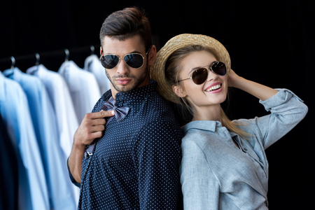happy young couple trying on stylish accessories in boutique の写真素材