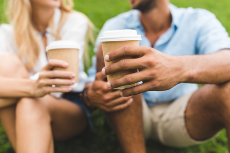 selective focus of man and woman with coffee to go in handsの写真素材