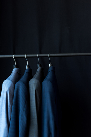 stylish male suit jackets on hangers in boutiqueの写真素材