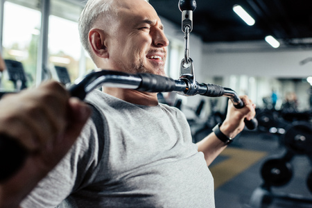 senior sportsman lifting weights in sport centerの写真素材