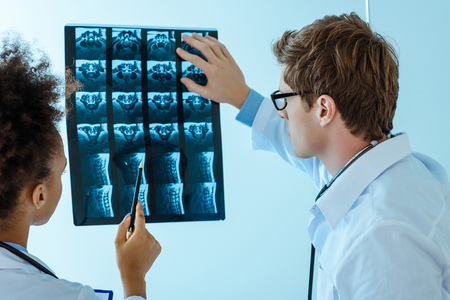 two young doctors examining an x-ray photographの写真素材