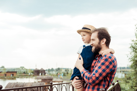 side view of happy father holding little daughter in hands in parkの写真素材