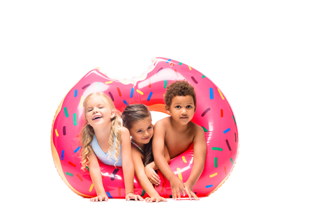 beautiful multiethnic kids having fun with swim tube isolated on white  の写真素材
