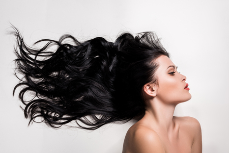 young woman with beautiful black hair isolated on whiteの写真素材