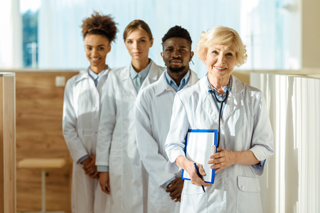 A multiracial group of doctors in lab coats standing in a row