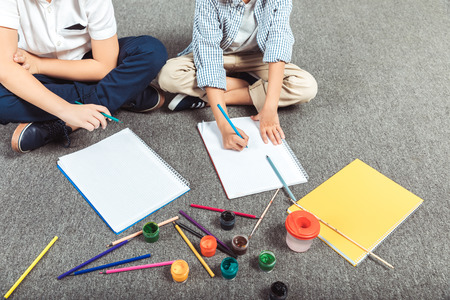 cropped shot of little boys drawing together at homeの写真素材
