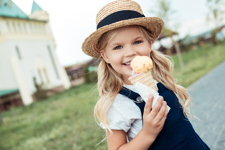 portrait of smiling little girl with ice cream in hand looking at cameraの写真素材