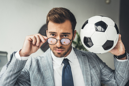 young handsome businessman in stylish eyeglasses with soccer ballの写真素材