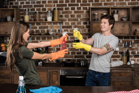 side view of cheerful couple having fun while cleaning home together