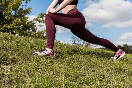 cropped shot of woman stretching legs outdoors before workout
