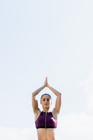 young woman with closed eyes in tree pose practicing yoga outdoorsの写真素材