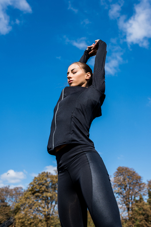 bottom view of young woman stretching outdoorsの写真素材