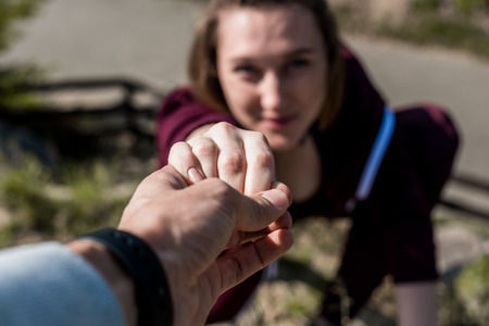 close-up shot of man giving helping hand to young woman to supportの写真素材