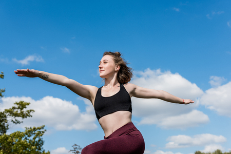 bottom view of young woman standing in warrior pose while practicing yogaの写真素材