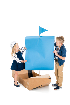 happy boy and girl playing with toy yacht isolated on whiteの写真素材