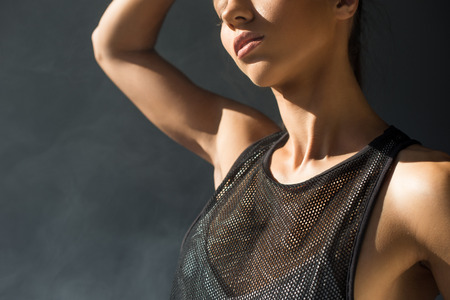 cropped shot of beautiful seductive girl posing in smoke in greyの写真素材