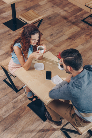high angle view of couple drinking coffee while spending time together in cafeの写真素材