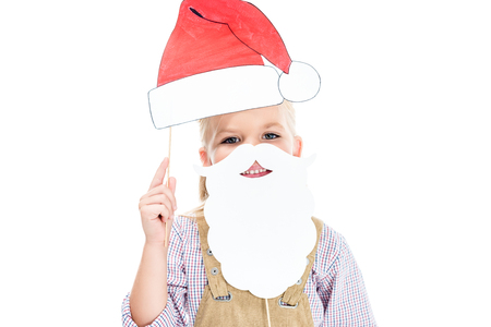 portrait of smiling little girl holding santa hat and fake beard isolated on whiteの写真素材