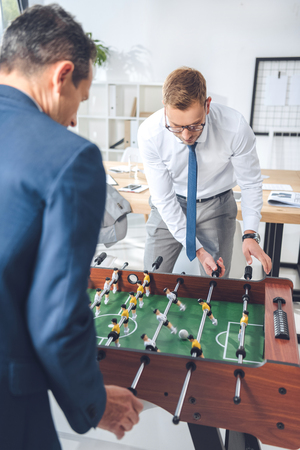 handsome businessmen playing table football in modern officeの写真素材