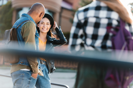 selective focus of smiling asian woman looking at african american friend near by on streetの写真素材