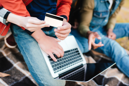 partial view of friends with laptop shopping online togetherの写真素材