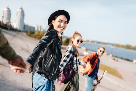 cropped shot of happy multicultural friends holding hands on streetの写真素材