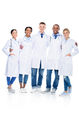 multiethnic female and male hugging doctors in white coats, isolated on whiteの写真素材