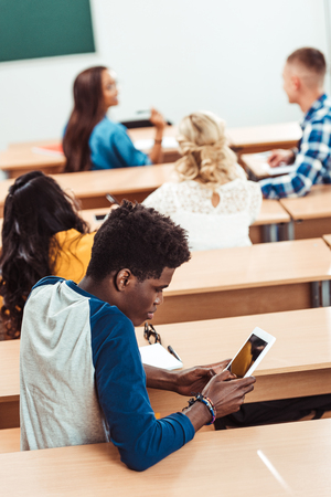 african american student using tablet on lecture with classmates on backgroundの写真素材