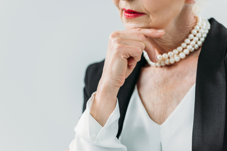 cropped view of pensive senior lady with pearl necklace, isolated on greyの写真素材