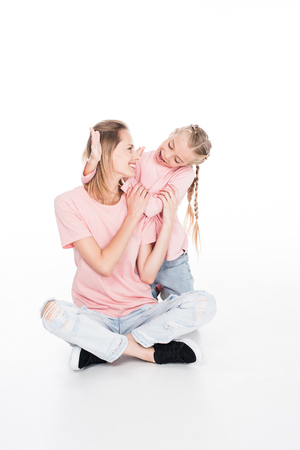 happy daughter closing eyes to her mother and making surprise, isolated on white の写真素材