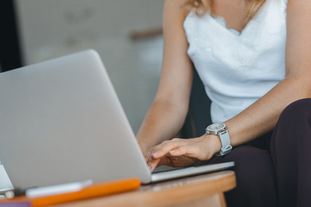 close-up partial view of woman using laptopの写真素材