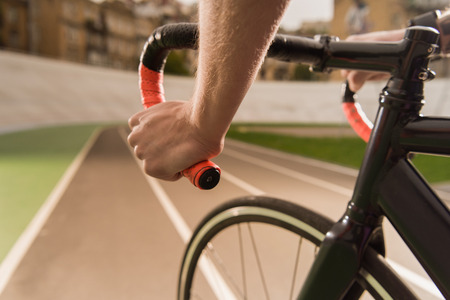 partial view of cyclist riding bicycle during race on cycle race track