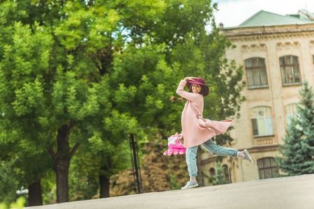 beautiful happy young woman holding roller skates and walking in parkの写真素材
