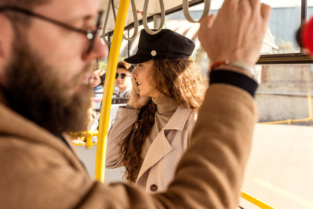 selective focus of smiling woman talking on smartphone in public transportの写真素材