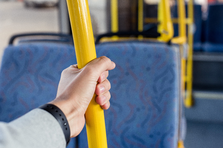 partial view of male hand holding bus handleの写真素材