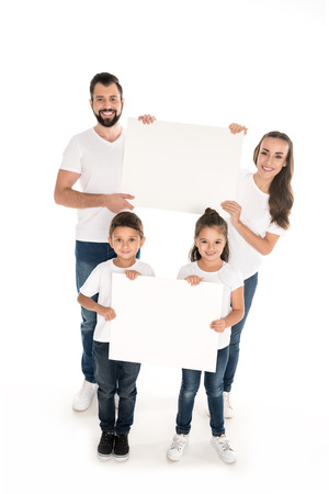cheerful family holding blank banners in hands isolated on whiteの写真素材