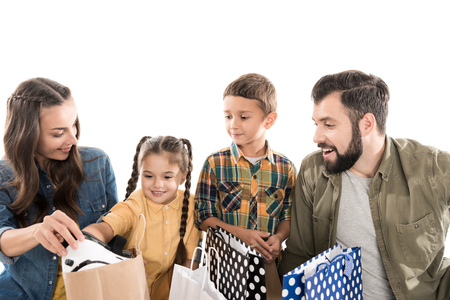 smiling family with kids holding shopping bags, isolated on whiteの写真素材